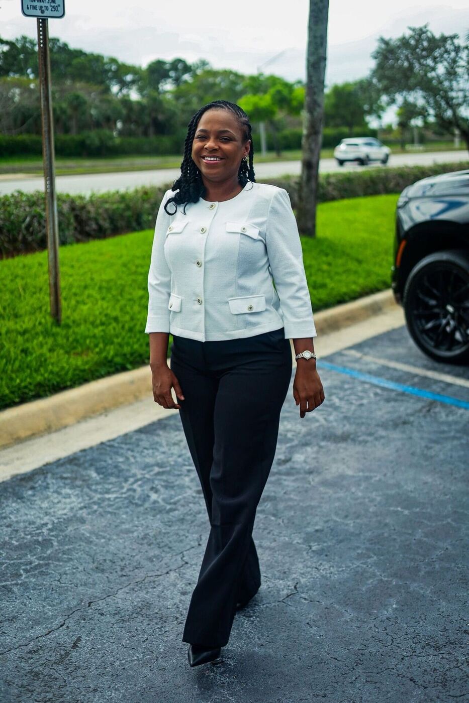 MS Luxury Black Car female chauffeur walking toward the vehicle