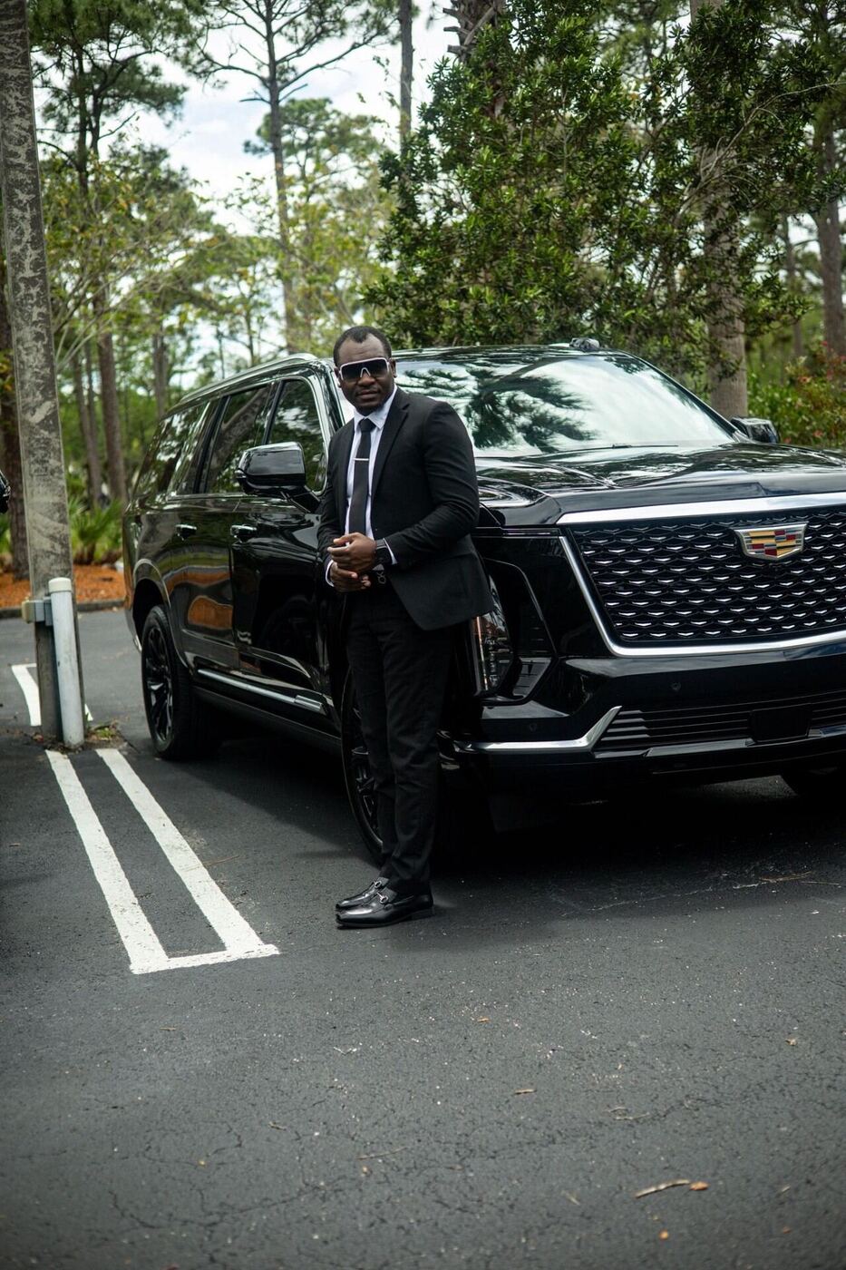 Owner leaning on a black Cadillac Escalade ESV
